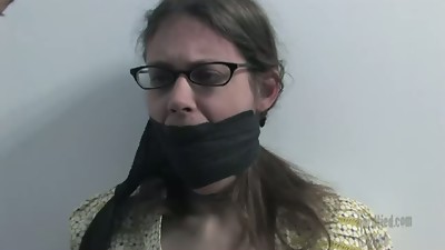 Masked slender brunette with her hands tied behind her back sucks dick